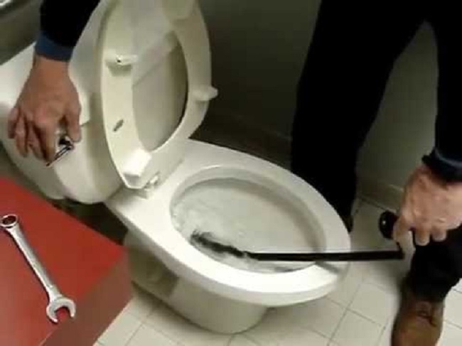 Xử lý bồn cầu nghẹt vật cứng bằng dây lò xo